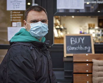 Portrait of man wearing mask standing in cafe