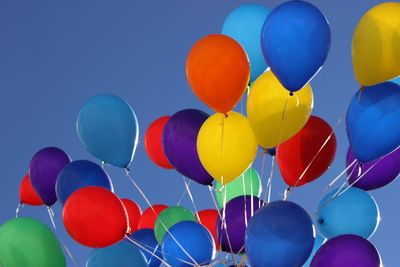 Low angle view of balloons against blue sky