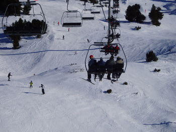 People enjoying in ski lift over snow covered mountain