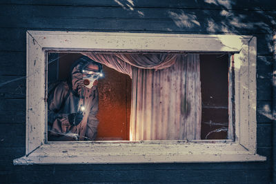 Fictional movie poster. people with flashlights, masks and protective clothing inspect old house. 