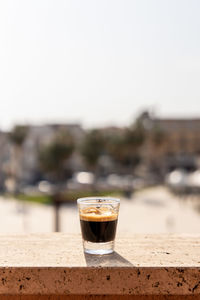 Close-up of beer glass on table against clear sky