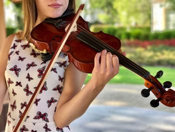 Midsection of woman playing violin