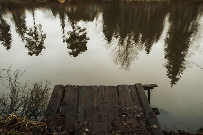 High angle view of wooden post by lake against sky