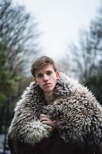 Portrait of young man wearing fur coat during winter