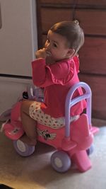 Cute boy looking away while sitting on sofa at home