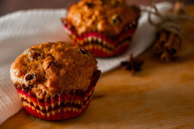 Homemade muffins with raisins on a wooden background. cupcake in a paper mold on a white napkin.