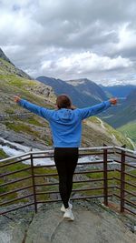 Full length of woman standing on boardwalk against sky