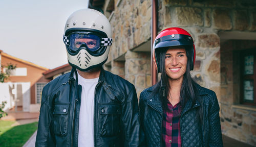 Couple wearing helmets while standing in city