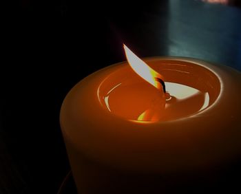 Close-up of lit candle in dark