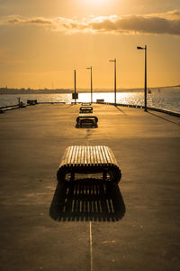 Vertical shot of four benches in line on the wharf. warm tones of the golden hour