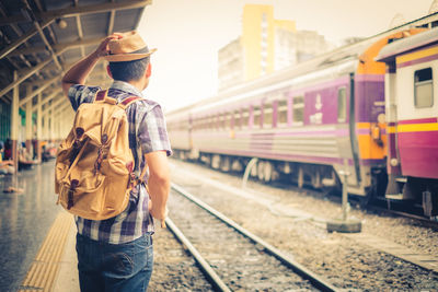 Rear view of man standing by train