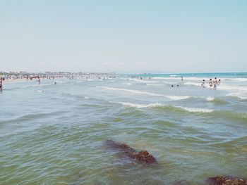 People on beach against clear sky