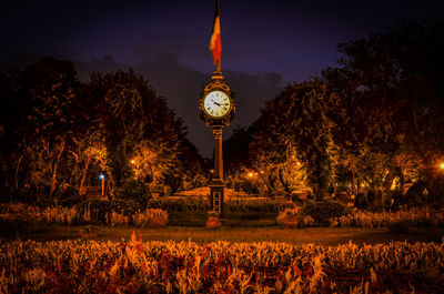 Antique clock in park against sky at dusk