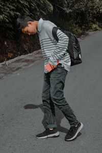 Side view of man standing on road