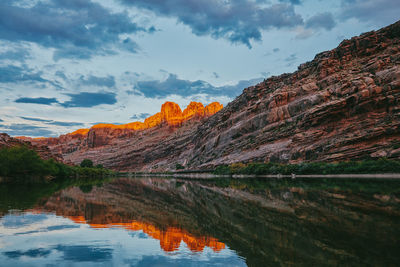 Scenic view of lake by mountains against sky