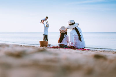 People at beach against sky