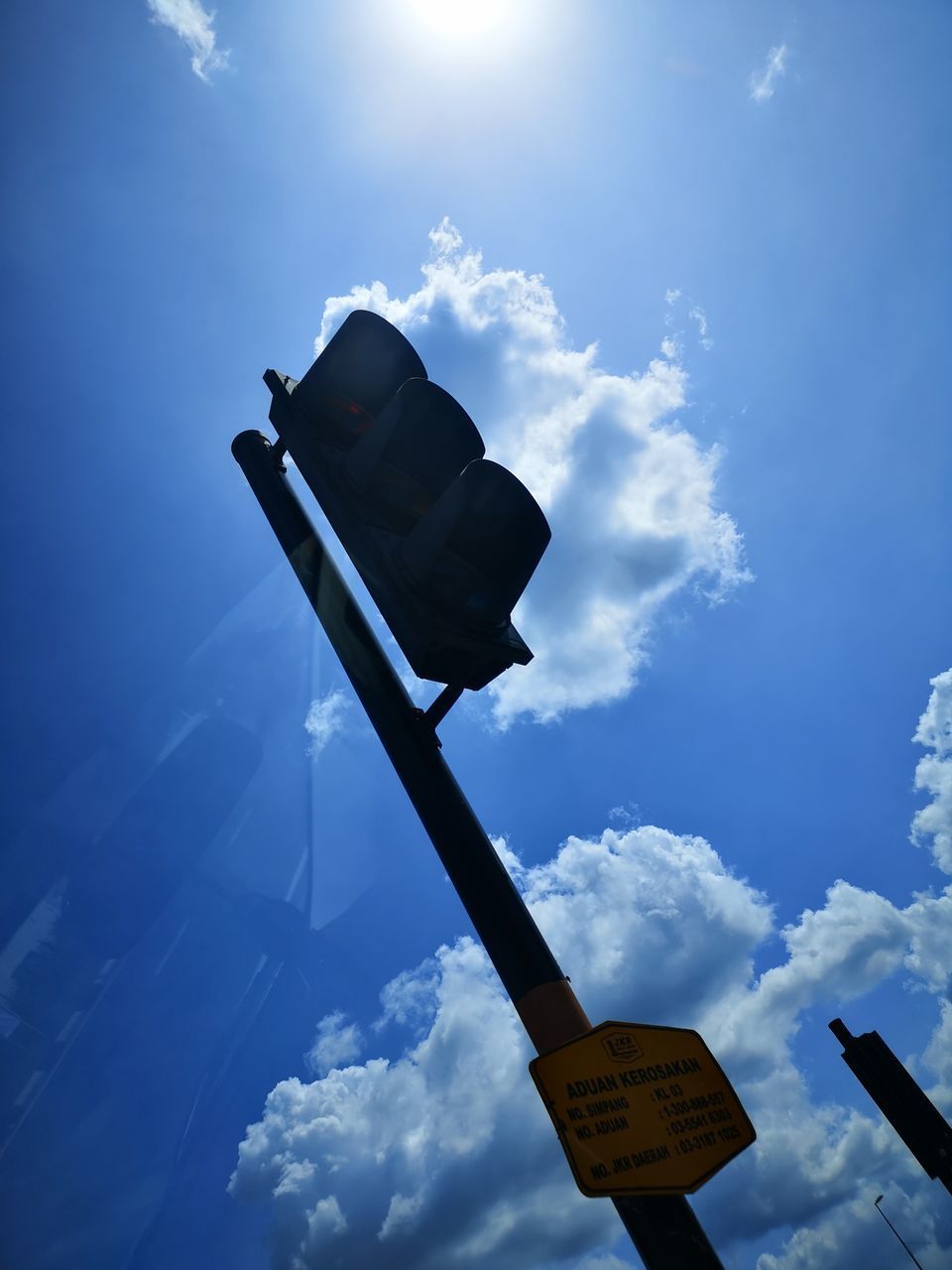 LOW ANGLE VIEW OF ROAD SIGN BY STREET AGAINST SKY