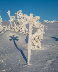 Snow covered land on field against sky