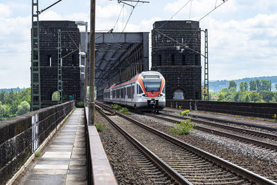 Railroad tracks in train against sky