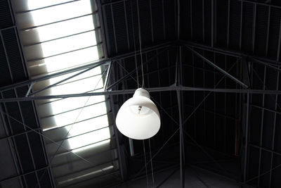 Low angle view of illuminated pendant light hanging from ceiling