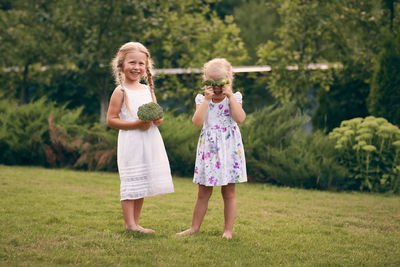 Full length of sisters standing in park