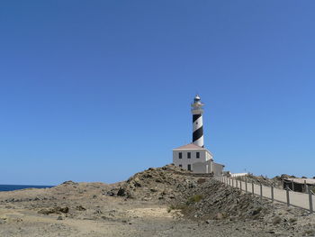 Low angle view of lighthouse against clear blue sky