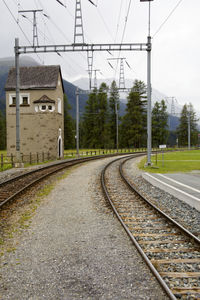 Railroad tracks by trees against sky