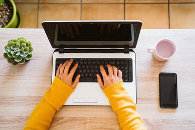 High angle view of person using laptop on table