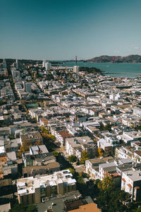 High angle view of townscape by sea against clear sky