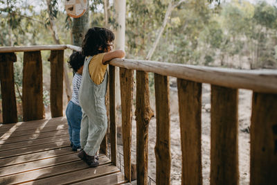 Rear view of woman standing on footbridge