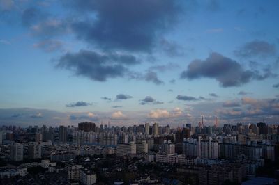 View of cityscape against cloudy sky