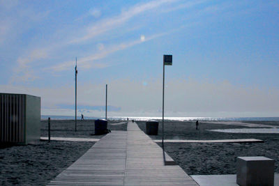 Street leading towards sea against sky