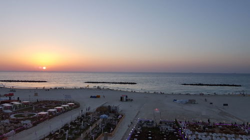 High angle view of people on beach against sky during sunset