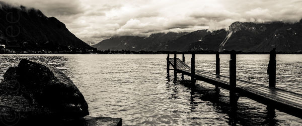 Scenic view of lake and mountains against cloudy sky