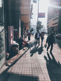 People walking on footpath in city