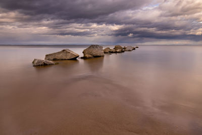 Rocks on beach against sky