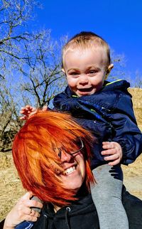 Smiling carrying baby boy on shoulder