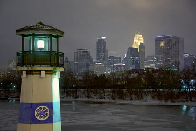 Illuminated clock tower in city at night