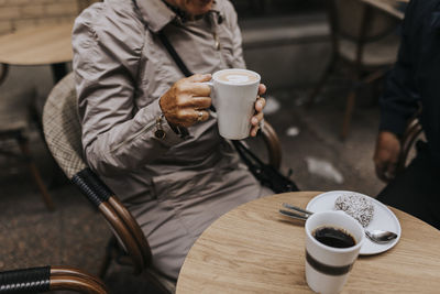 Senior woman holding coffee cup in cafe