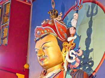 Low angle view of buddha statue against building