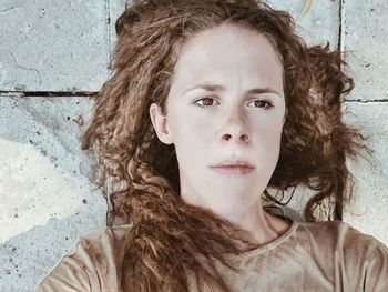 Portrait of young woman against wall