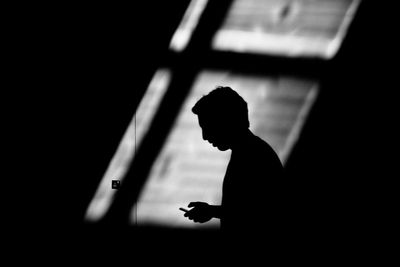 Silhouette of man using mobile phone