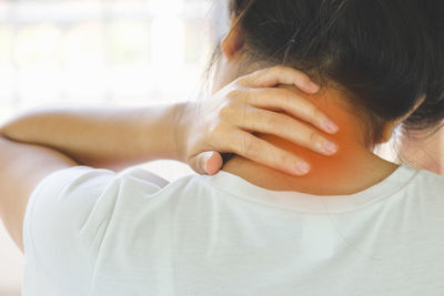 Rear view of woman suffering from neckache