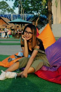 Full length of a smiling young woman sitting outdoors