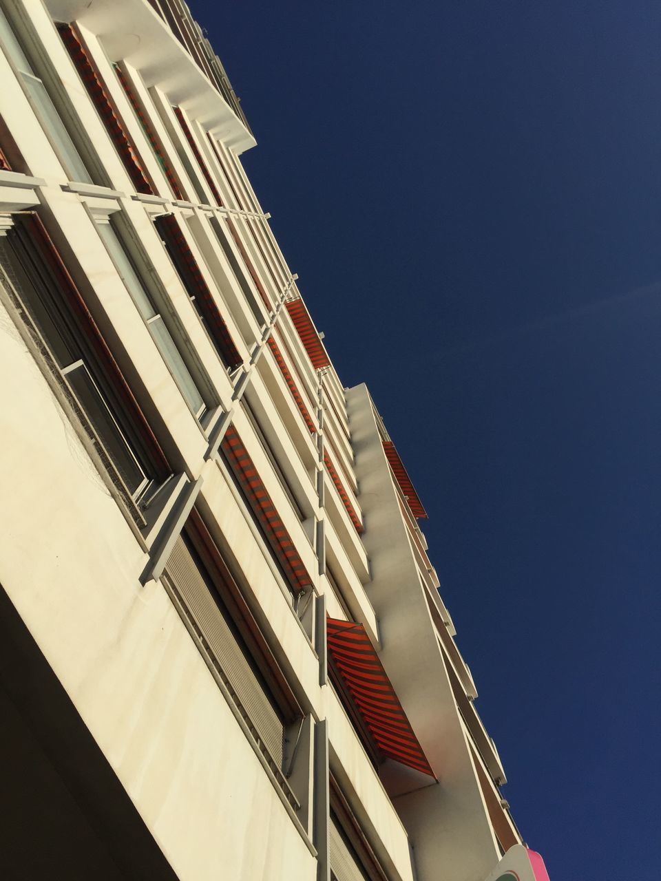 LOW ANGLE VIEW OF BUILDINGS AGAINST CLEAR BLUE SKY