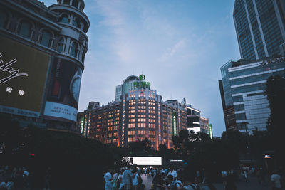 People on buildings in city against sky
