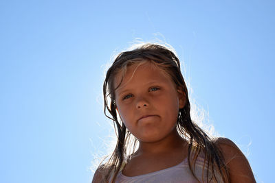 Portrait of cute girl against blue sky