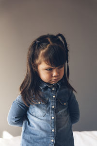 Close-up of cute girl against wall