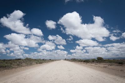 Road amidst landscape against blue sky