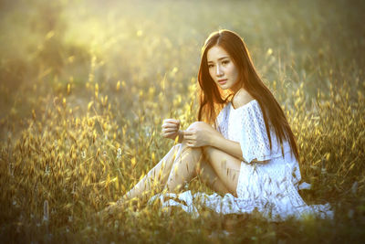 Young woman sitting on field